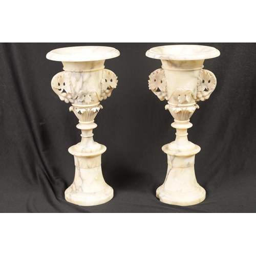 489 - A PAIR OF 19TH CENTURY FRENCH ALABASTER MANTEL URNS of sectional form with pedestal bases and leaf-c... 