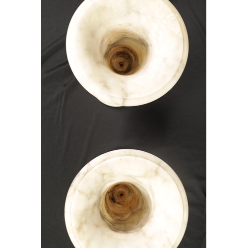 489 - A PAIR OF 19TH CENTURY FRENCH ALABASTER MANTEL URNS of sectional form with pedestal bases and leaf-c... 