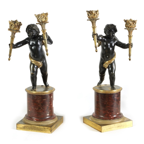 490 - A PAIR OF EARLY 19TH CENTURY FRENCH GILT BRONZE AND ROUGE MARBLE TWO BRANCH CHERUB CANDELABRA modell... 