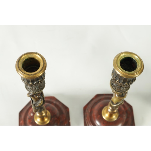 500 - A PAIR OF 19TH CENTURY BRONZE FIGURAL CANDLESTICKS the fluted sconces with removable rims on leaf en... 