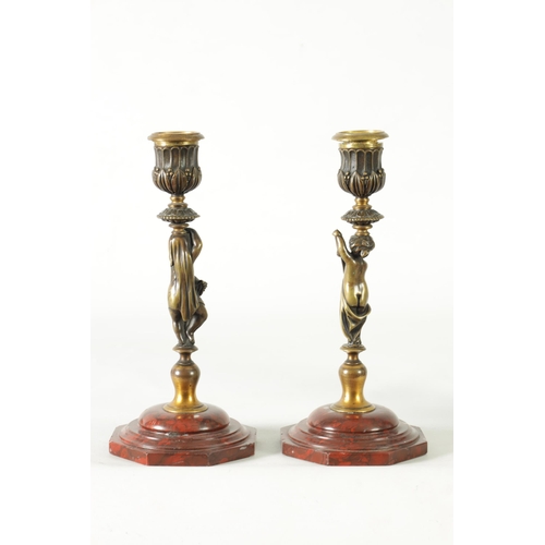 500 - A PAIR OF 19TH CENTURY BRONZE FIGURAL CANDLESTICKS the fluted sconces with removable rims on leaf en... 