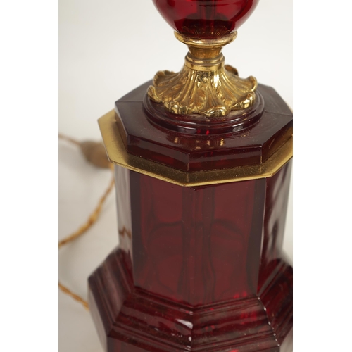 501 - A PAIR OF FRENCH 19TH CENTURY STYLE RUBY GLASS AND GILT BRASS TABLE LAMPS with chased and leaf cast ... 