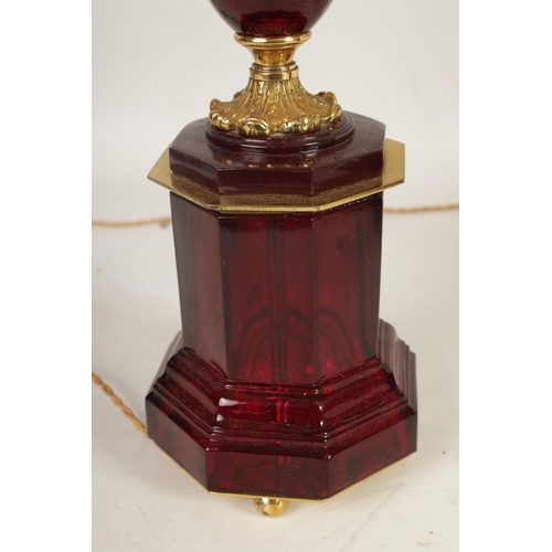 501 - A PAIR OF FRENCH 19TH CENTURY STYLE RUBY GLASS AND GILT BRASS TABLE LAMPS with chased and leaf cast ... 