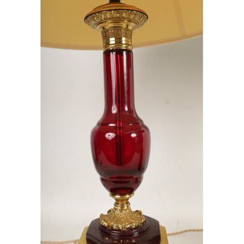 501 - A PAIR OF FRENCH 19TH CENTURY STYLE RUBY GLASS AND GILT BRASS TABLE LAMPS with chased and leaf cast ... 