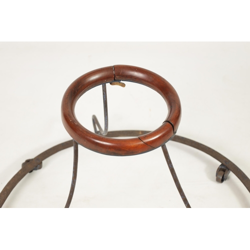 505 - A 19TH CENTURY IRONWORK AND MAHOGANY BABY WALKER the spreading rivetted base on four revolving casto... 