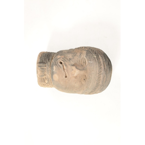 517 - AN EARLY EASTERN CARVED RED SANDSTONE HEAD realistically modelled wearing head dress (36cm high 24cm... 