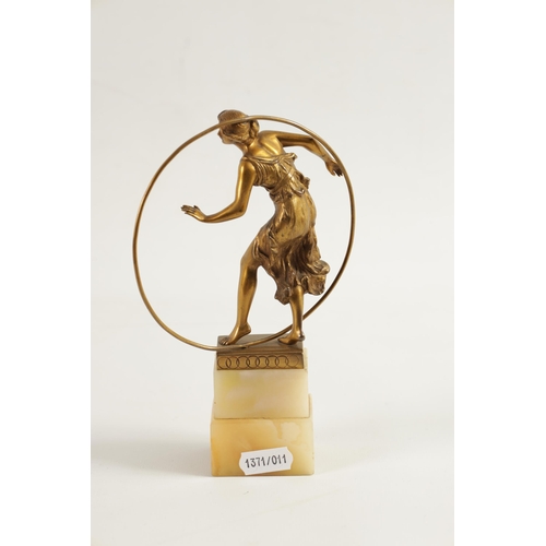 520 - AN ART DECO GILT BRONZE FIGURE GROUP depicitng a 'Hoop Girl' mounted on a stepped onyx base. (18cm h... 