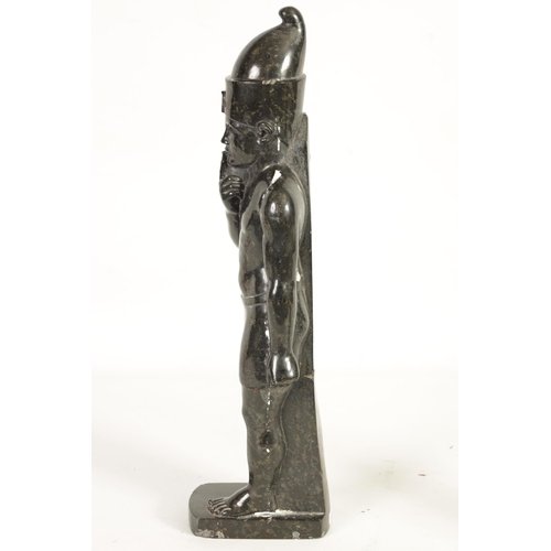 523 - AN UNUSUAL CARVED MARBLE EGYPTIAN STYLE FIGURE OF A STANDING MAN mounted on a rectangular shaped bas... 