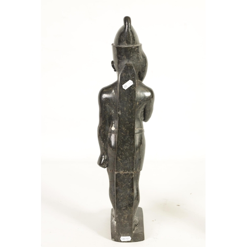 523 - AN UNUSUAL CARVED MARBLE EGYPTIAN STYLE FIGURE OF A STANDING MAN mounted on a rectangular shaped bas... 