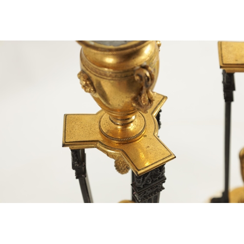 537 - A PAIR OF REGENCY FRENCH EMPIRE BRONZE AND ORMOLU CANDLESTICKS with urn shaped tops above triform su... 