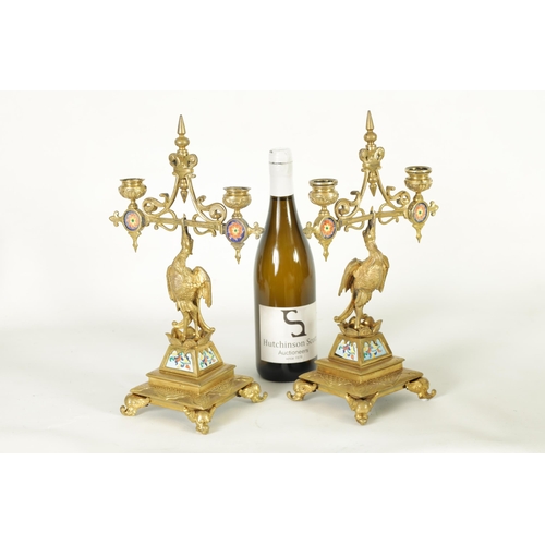 556 - A PAIR OF LATE 19TH CENTURY BRASS AESTHETIC PERIOD DOUBLE BRANCH CANDELABRA set with porcelain panel... 