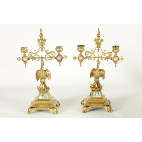 556 - A PAIR OF LATE 19TH CENTURY BRASS AESTHETIC PERIOD DOUBLE BRANCH CANDELABRA set with porcelain panel... 