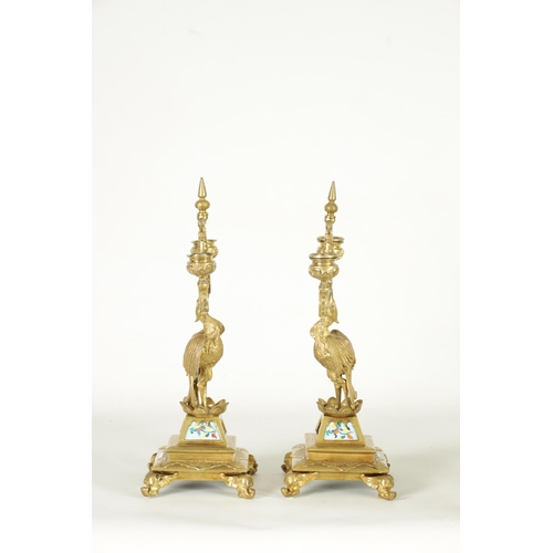 556 - A PAIR OF LATE 19TH CENTURY BRASS AESTHETIC PERIOD DOUBLE BRANCH CANDELABRA set with porcelain panel... 