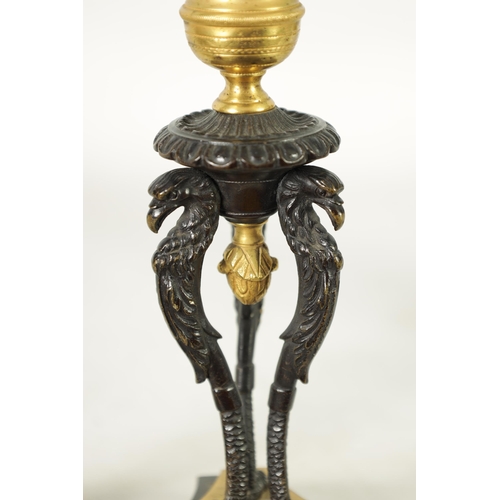 562 - A PAIR OF FRENCH EMPIRE BRONZE AND ORMOLU CANDLESTICKS with griffin mounts and triform pedestal base... 