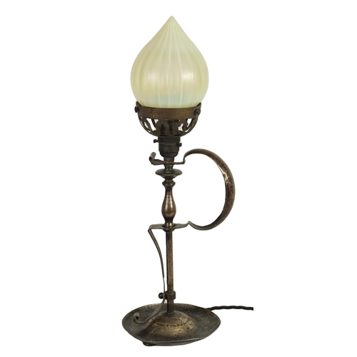 589 - A PATINATED BRASS ART AND CRAFTS TABLE LAMP WITH VASELINE GLASS SHADE surmounted by a cone-shaped sh... 