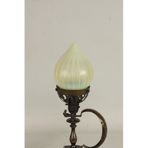 589 - A PATINATED BRASS ART AND CRAFTS TABLE LAMP WITH VASELINE GLASS SHADE surmounted by a cone-shaped sh... 