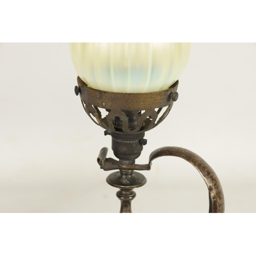 589 - A PATINATED BRASS ART AND CRAFTS TABLE LAMP WITH VASELINE GLASS SHADE surmounted by a cone-shaped sh... 