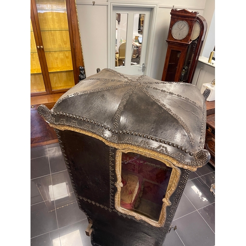 103 - AN EARLY/MID 18TH CENTURY CARVED GILT-WOOD AND STUDDED LEATHER SEDAN CHAIR with shaped domed top abo... 