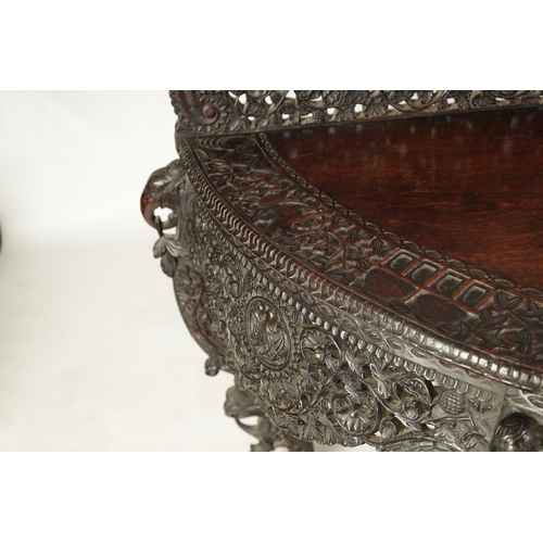 255 - A 19TH CENTURY ANGLO-INDIAN CARVED HARDWOOD DEMI LUNE SERVING TABLE with profusely carved and pierce... 