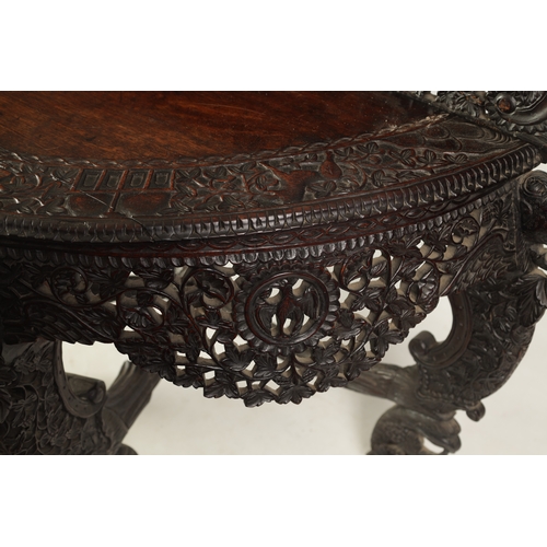 255 - A 19TH CENTURY ANGLO-INDIAN CARVED HARDWOOD DEMI LUNE SERVING TABLE with profusely carved and pierce... 