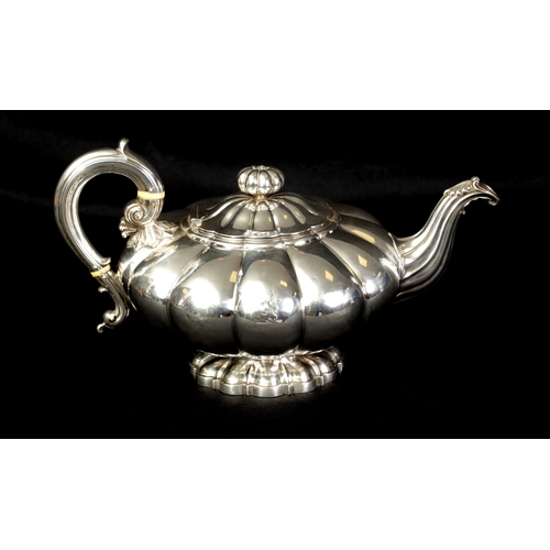 324 - A GEORGE IV FOOTED MELON SHAPED SILVER TEA POT the gadrooned body bearing an engraved lion motif wit... 