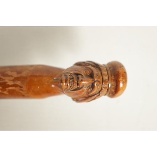 469 - AN EARLY 19TH CENTURY CARVED WALKING STICK modelled as a head of an old lady on a notched branchwork... 