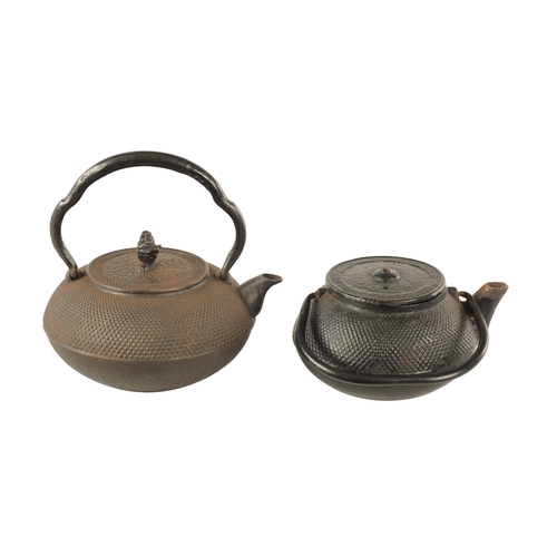 148 - TWO MEIJI PERIOD JAPANESE CAST IRON KETTLES both of squat bulbous form with textured decoration and ... 