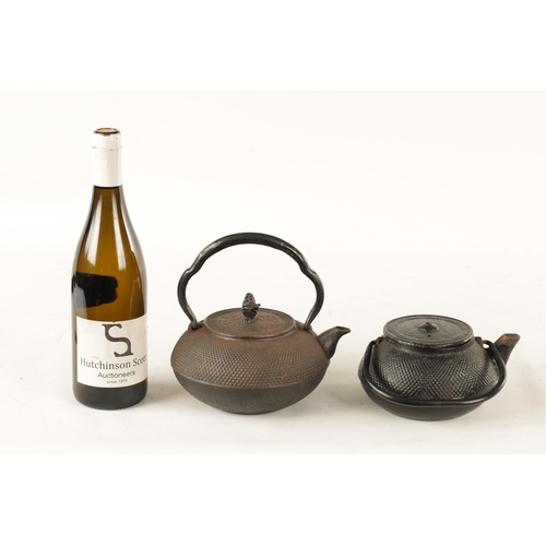 148 - TWO MEIJI PERIOD JAPANESE CAST IRON KETTLES both of squat bulbous form with textured decoration and ... 
