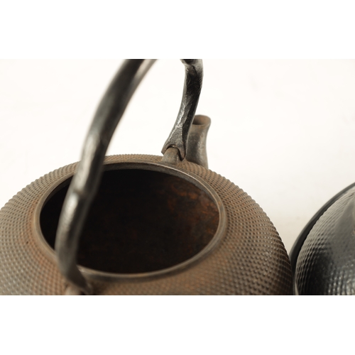 148 - TWO MEIJI PERIOD JAPANESE CAST IRON KETTLES both of squat bulbous form with textured decoration and ... 