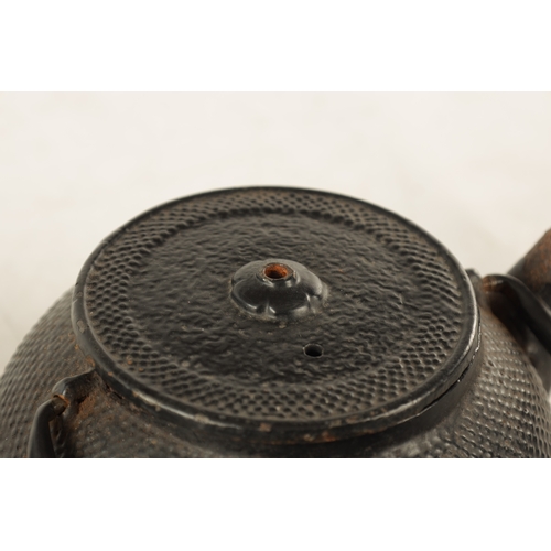 148 - TWO MEIJI PERIOD JAPANESE CAST IRON KETTLES both of squat bulbous form with textured decoration and ... 