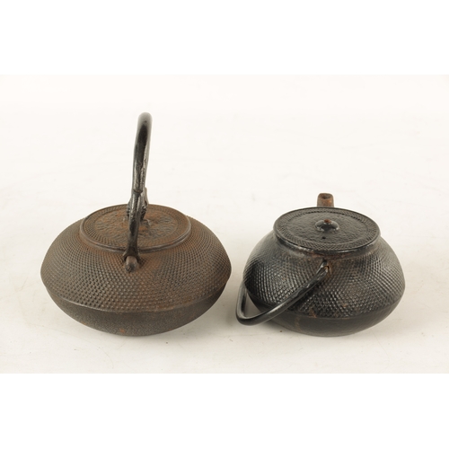 148 - TWO MEIJI PERIOD JAPANESE CAST IRON KETTLES both of squat bulbous form with textured decoration and ... 