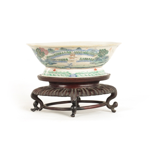 168 - A 19TH CENTURY CHINESE PORCELAIN DISH ON HARDWOOD STAND decorated with landscape views of a palace b... 