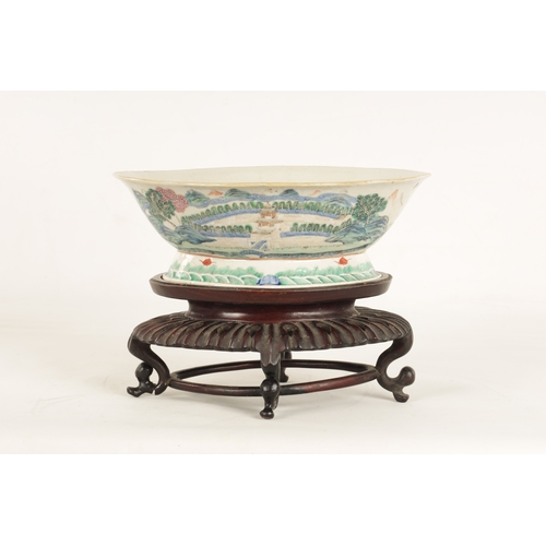 168 - A 19TH CENTURY CHINESE PORCELAIN DISH ON HARDWOOD STAND decorated with landscape views of a palace b... 