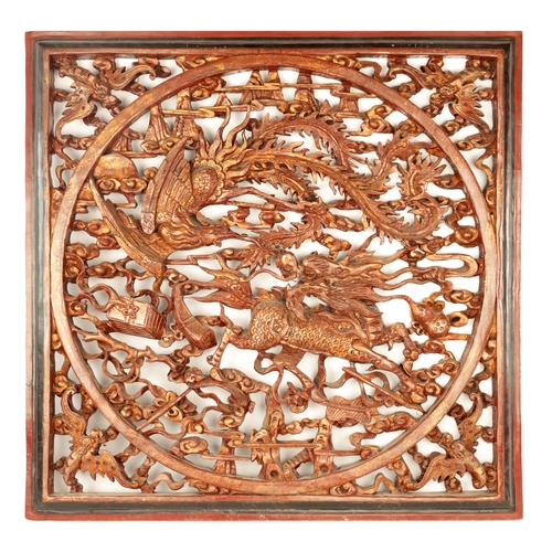 180 - A CHINESE CARVED LACQUERED HANGING PLAQUE having pierced centre depicting dragons amongst clouds (79... 