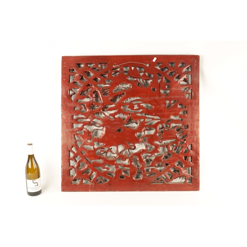 180 - A CHINESE CARVED LACQUERED HANGING PLAQUE having pierced centre depicting dragons amongst clouds (79... 