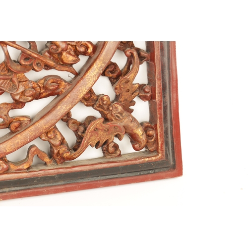 180 - A CHINESE CARVED LACQUERED HANGING PLAQUE having pierced centre depicting dragons amongst clouds (79... 