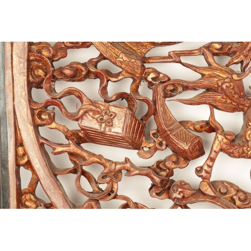 180 - A CHINESE CARVED LACQUERED HANGING PLAQUE having pierced centre depicting dragons amongst clouds (79... 
