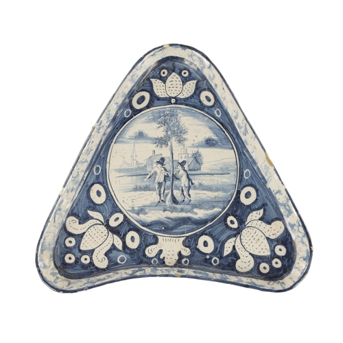 31 - AN 18TH/EARLY 19TH CENTURY DELFT/FAIENCE TRIANGULAR SHALLOW DISH with figural landscape centre, flor... 