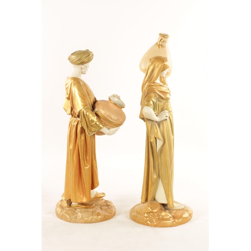 32 - A LARGE PAIR OF ROYAL WORCESTER STANDING FIGURES OF EASTERN WATER CARRIERS AFTER JAMES HADLEY depict... 
