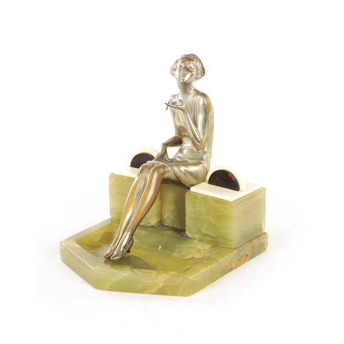 595 - ATT. JOSEF LORENZL. AN ART DECO SILVERED BRONZE FIGURAL INKSTAND modelled as a smoking girl seated o... 
