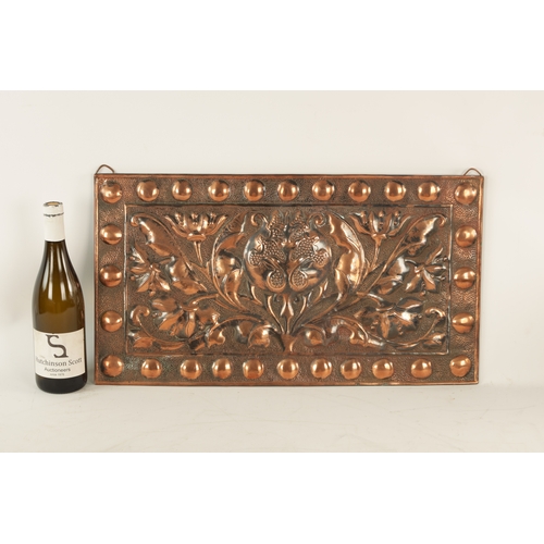549 - AN ARTS AND CRAFTS PLANISHED COPPER AND EMBOSSED WALL PLAQUE with roundel design border and embossed... 