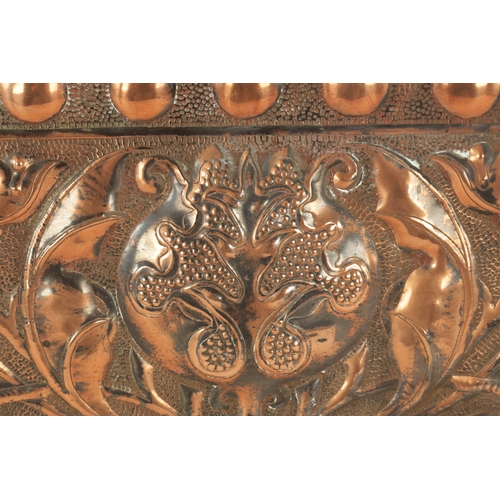 549 - AN ARTS AND CRAFTS PLANISHED COPPER AND EMBOSSED WALL PLAQUE with roundel design border and embossed... 