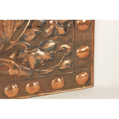 549 - AN ARTS AND CRAFTS PLANISHED COPPER AND EMBOSSED WALL PLAQUE with roundel design border and embossed... 