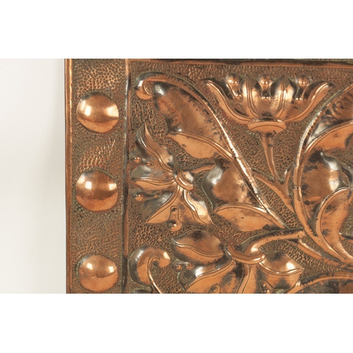 549 - AN ARTS AND CRAFTS PLANISHED COPPER AND EMBOSSED WALL PLAQUE with roundel design border and embossed... 
