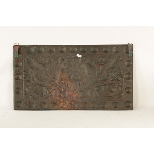 549 - AN ARTS AND CRAFTS PLANISHED COPPER AND EMBOSSED WALL PLAQUE with roundel design border and embossed... 