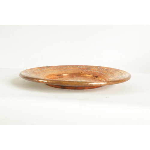 552 - AN ARTS AND CRAFTS HAMMERED COPPER HANGING CHARGER with geometric banded border and flower head star... 
