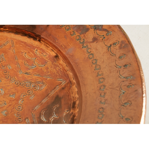 552 - AN ARTS AND CRAFTS HAMMERED COPPER HANGING CHARGER with geometric banded border and flower head star... 