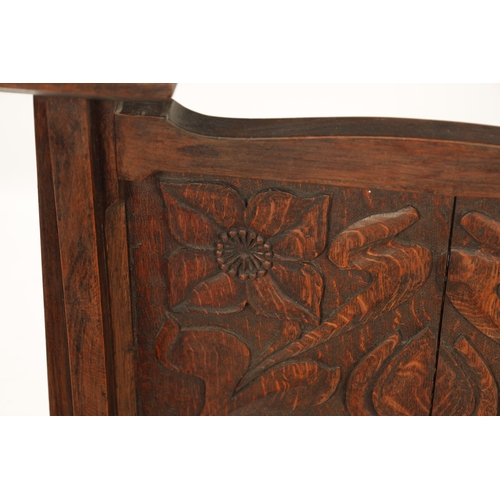 553 - A CARVED OAK ART NOUVEAU STYLE FIRE SCREEN with tulip carved panel raised on tapering side supports.... 