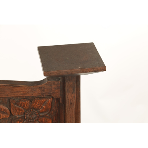553 - A CARVED OAK ART NOUVEAU STYLE FIRE SCREEN with tulip carved panel raised on tapering side supports.... 
