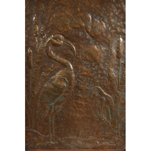 555 - AN ARTS AND CRAFTS PRESSED BRASS AND OAK FIRE SCREEN with pierced love heart decoration and angled f... 